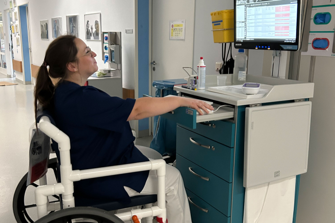 Kollegin im Rollstuhl bei der Arbeit am Computer